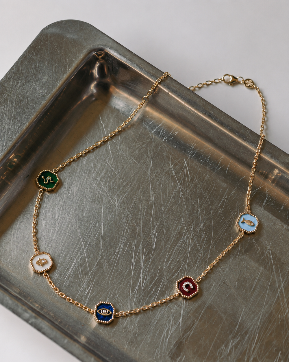 Five-medallion necklace styled on a tray